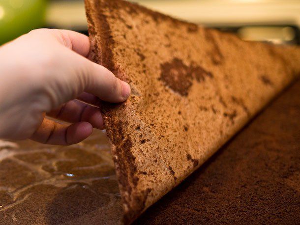 The parchment is peeled off of the inverted cake.