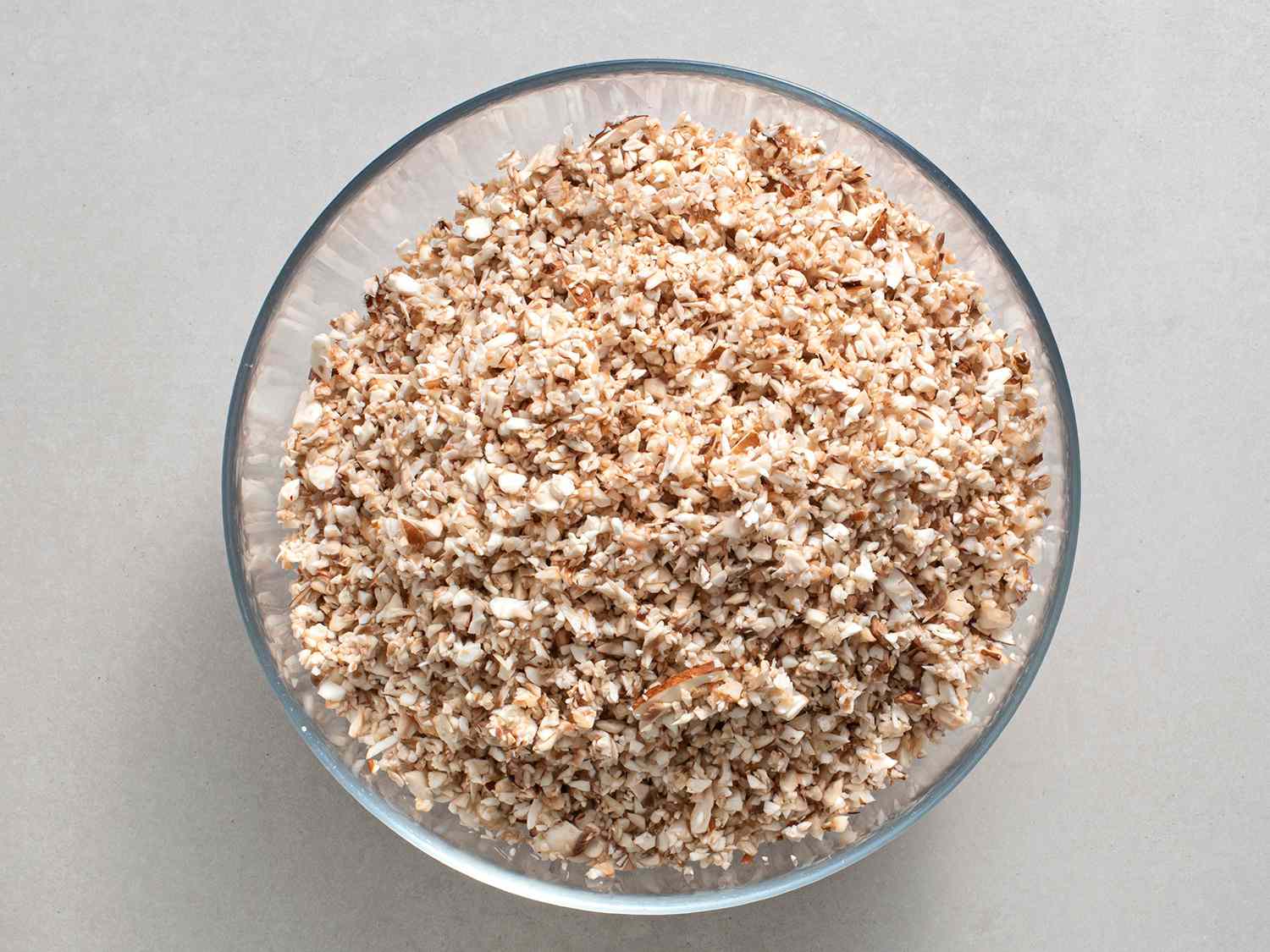 Finely chopped mushrooms in a glass bowl.