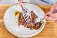 A person shreds meat cooked in the T-Fal Clipso Pressure Cooker using two forks