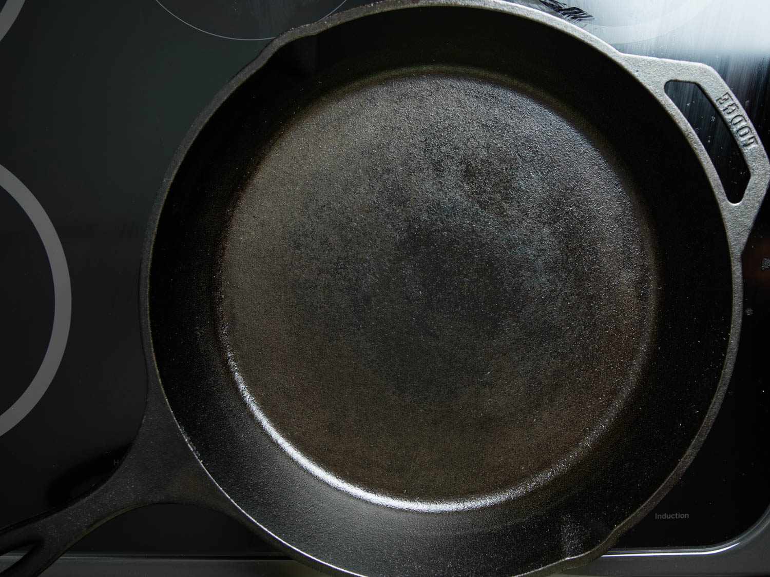 A cleaned and oiled cast iron pan, set on the heat to polymerize the oil into a new layer of seasoning.