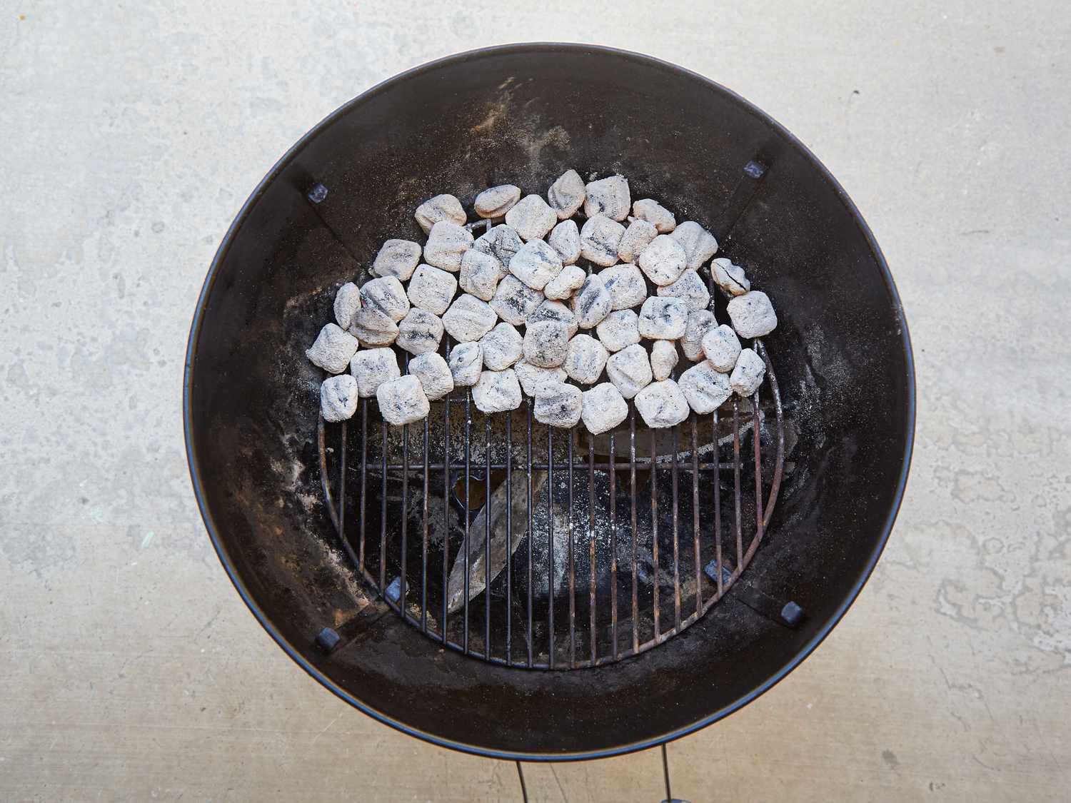 Charcoal briquettes arranged in a cooking grill, ready for grilling preparation