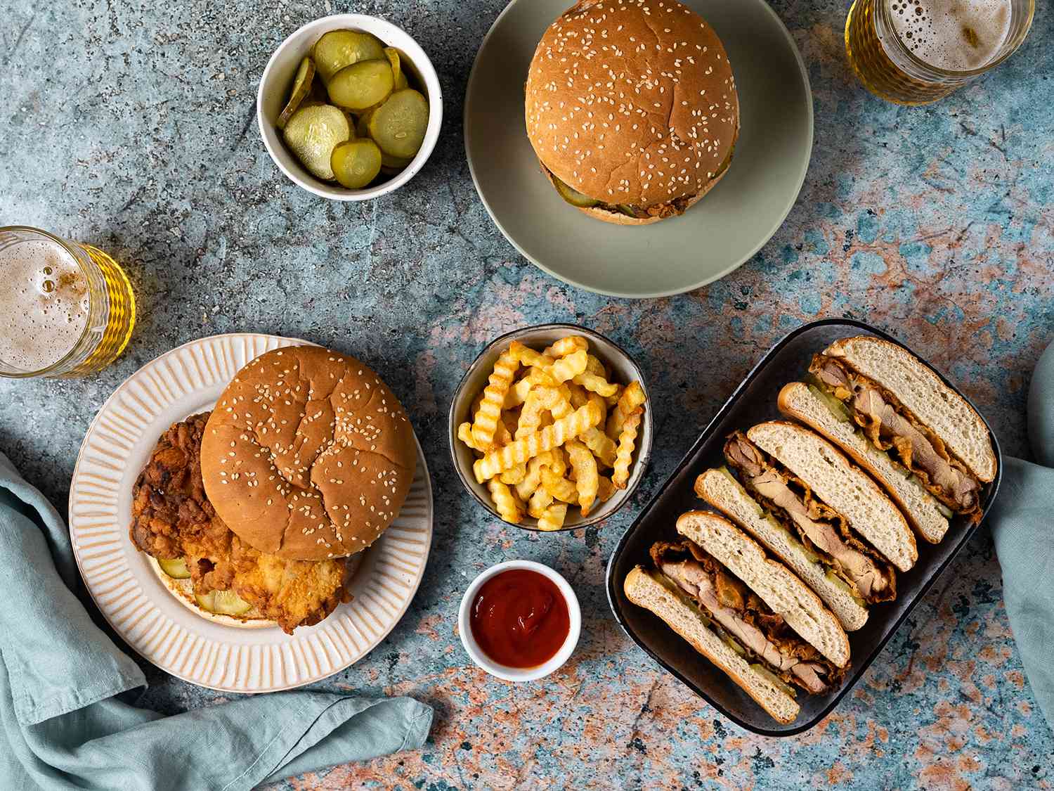 A tablescape showing fried chicken sandwiches, both whole and cut up.