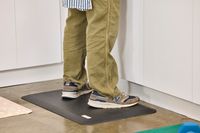 A person stands on top of the GelPro NewLife Bio-Foam Professional Anti-Fatigue Mat