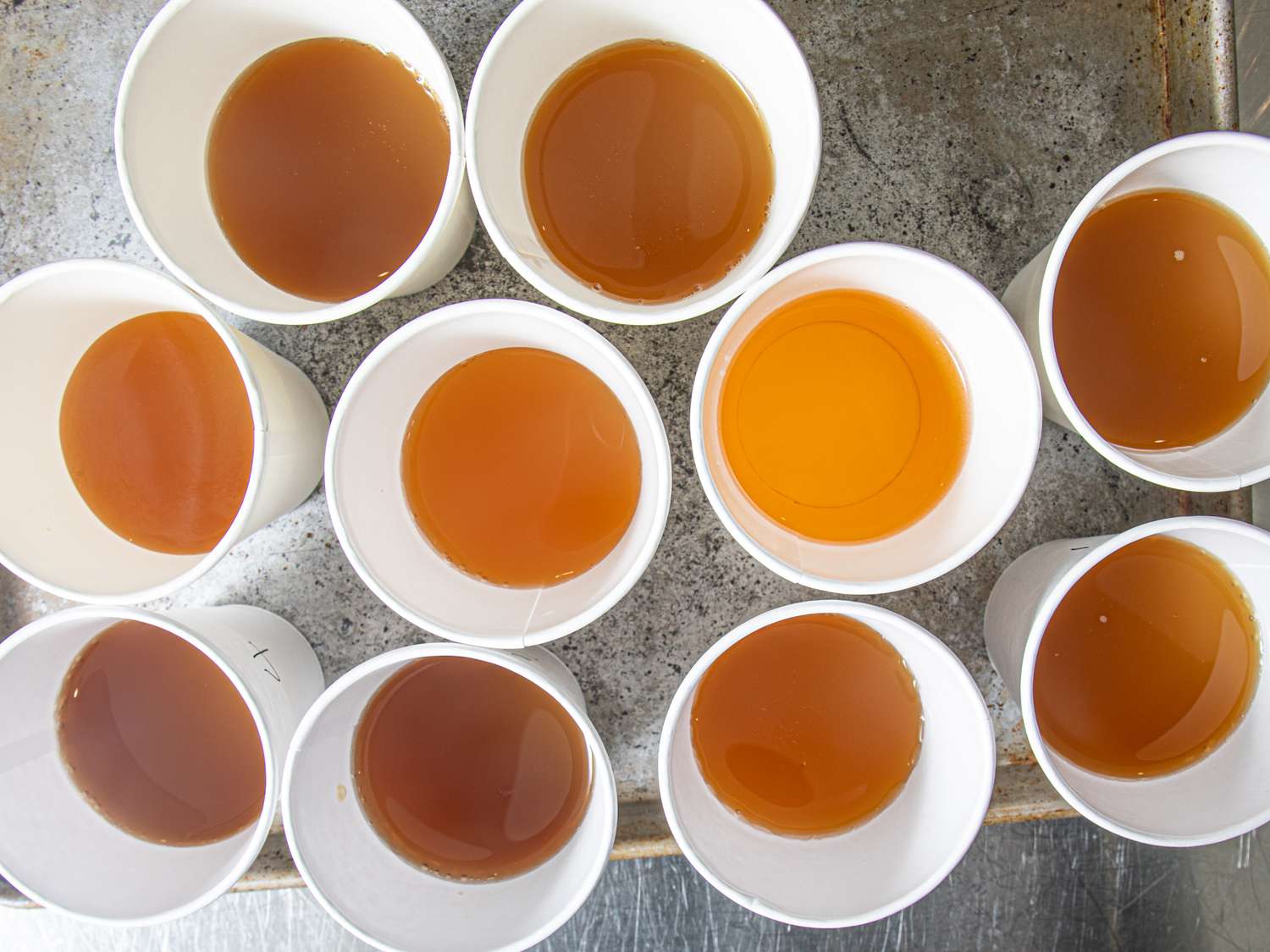 A selection of cups each filled with varying levels of apple cider