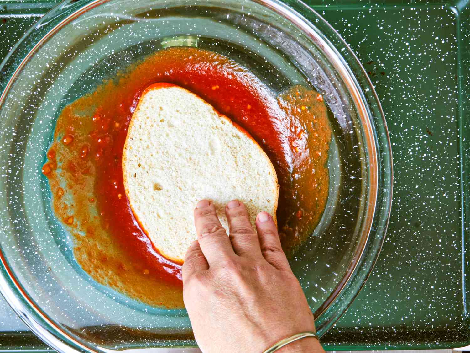 Overhead view of soaking bread in salsa