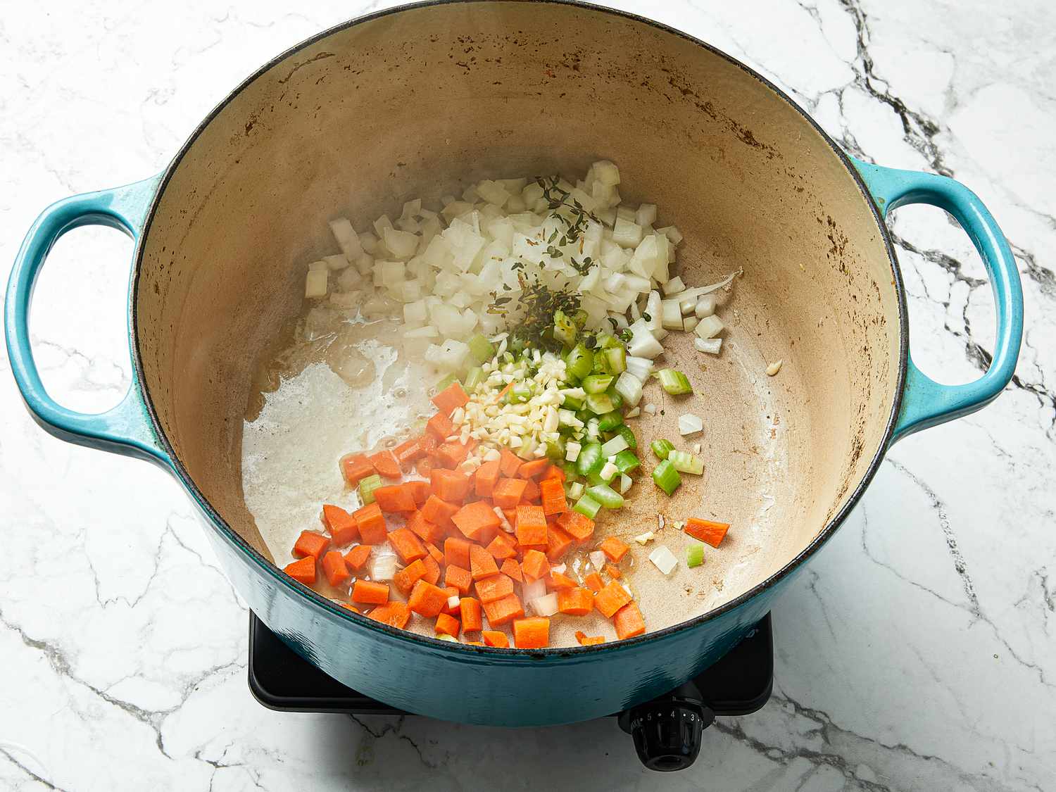 dutch oven with onion, carrot, celery, thyme and garlic