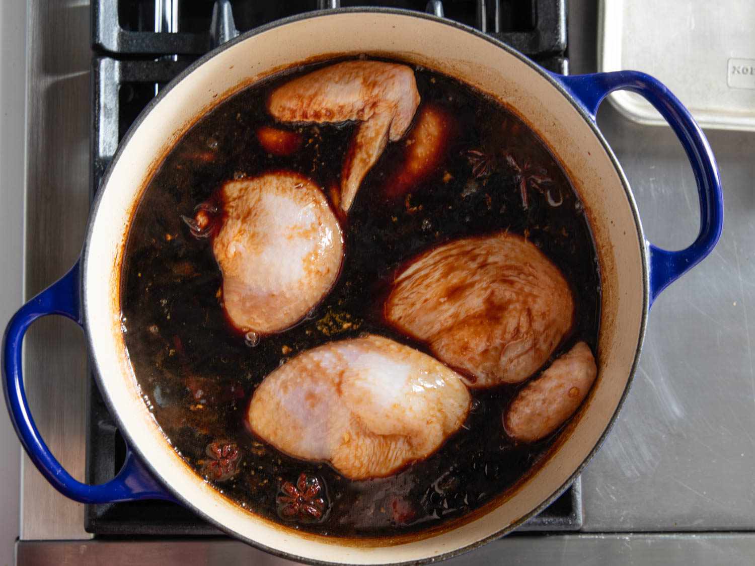 Chicken poaching in a sauce of soy and cola