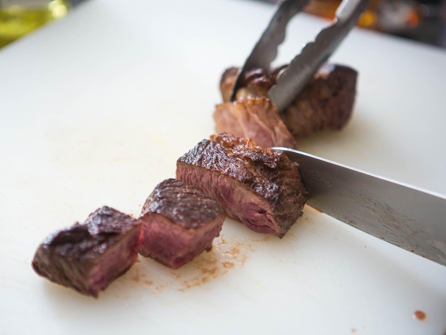 Cutting down browned larger cut of beef into smaller pieces