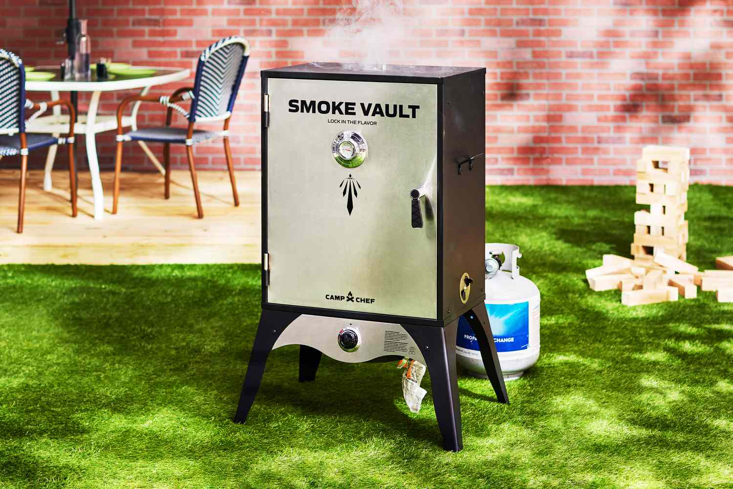 The Camp Chef Smoke Vault smoker sits in a backyard.