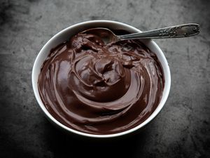 A bowl of chocolate pudding with spoon
