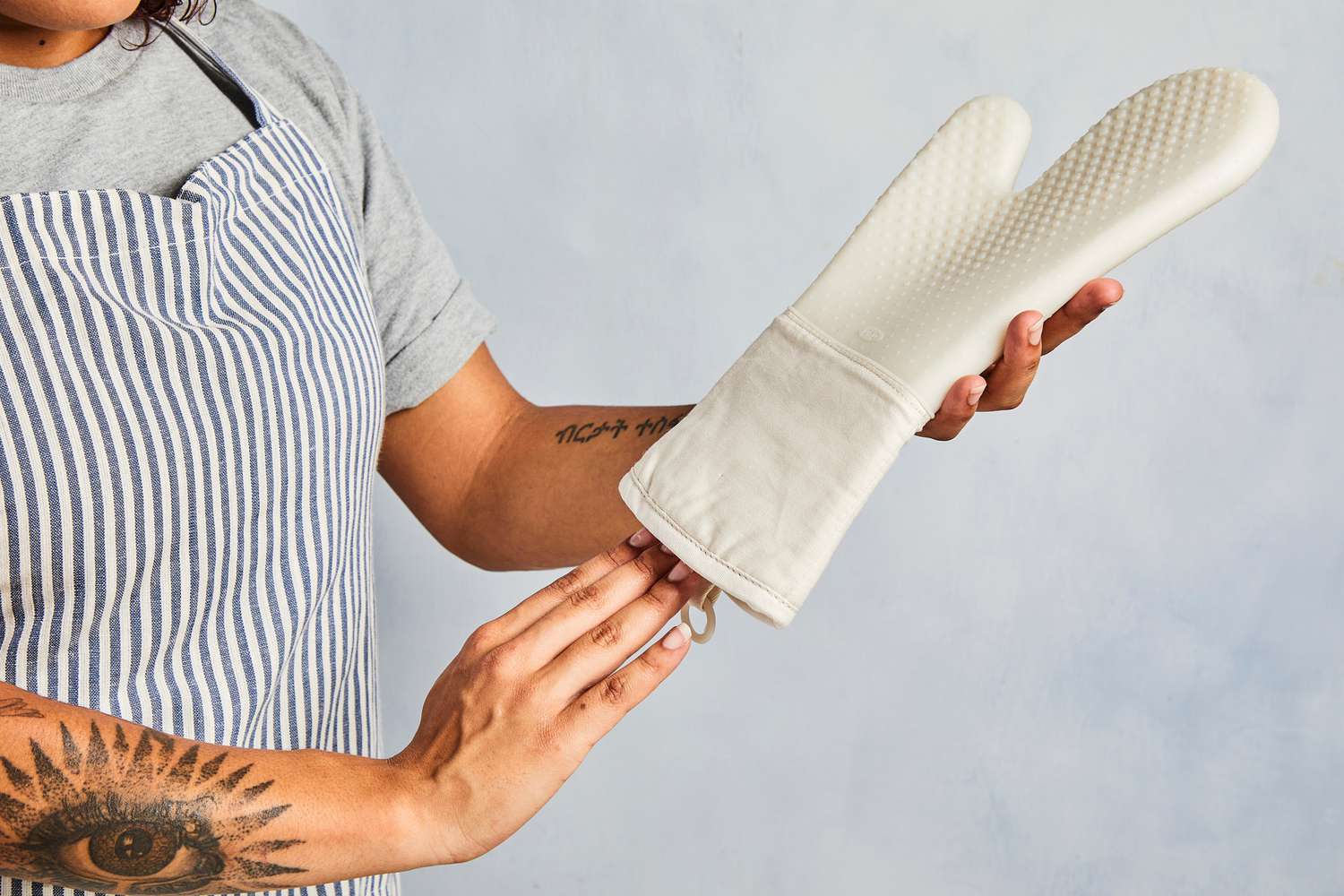 a person putting their hand into the oxo oven mitt
