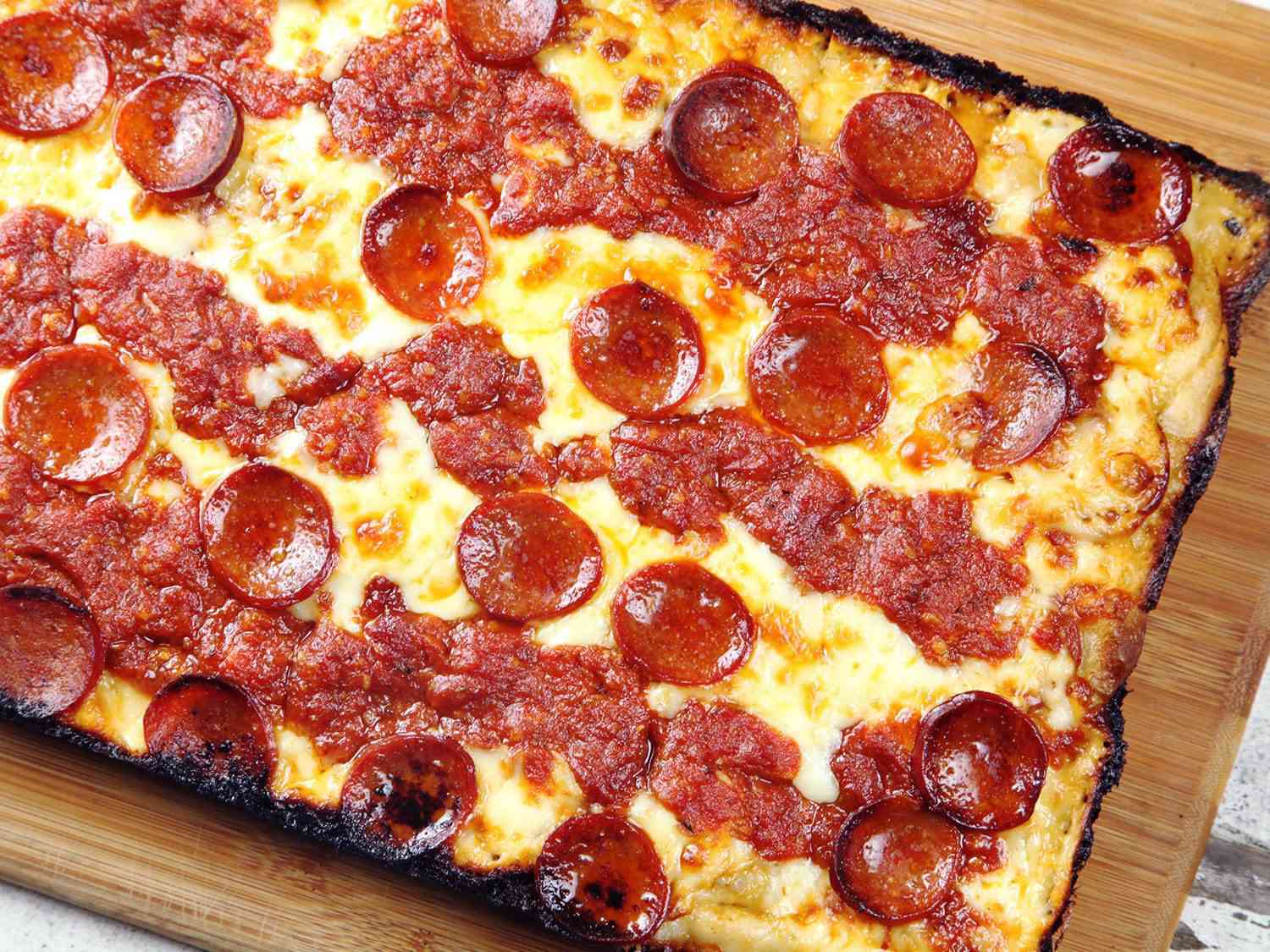 A Detroit-style pizza resting on a cutting board.