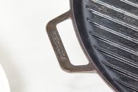 Close-up of the Victoria Cast Iron Square Grill Pan's handle.