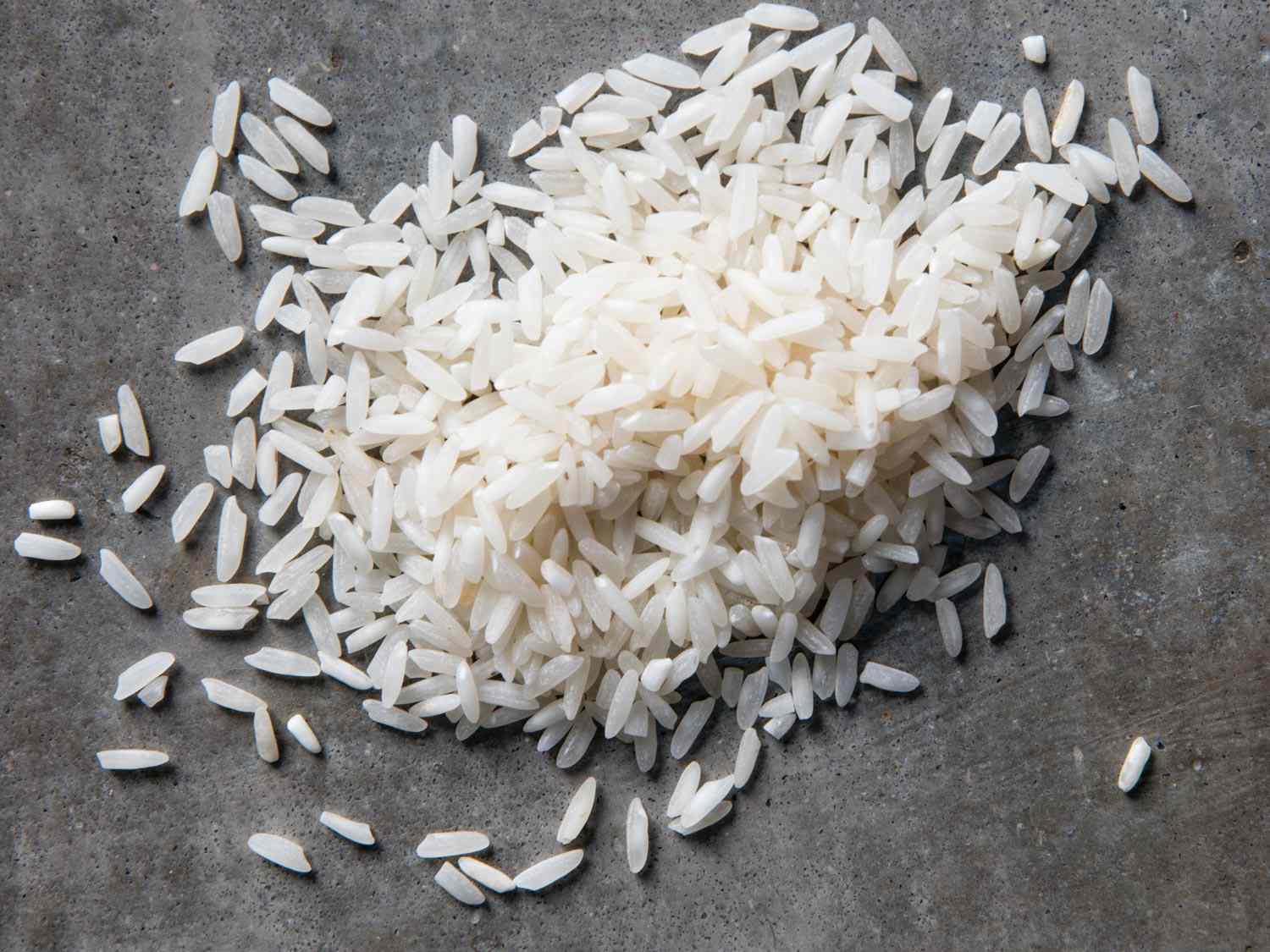 Overhead shot of small pile of white rice against grey background
