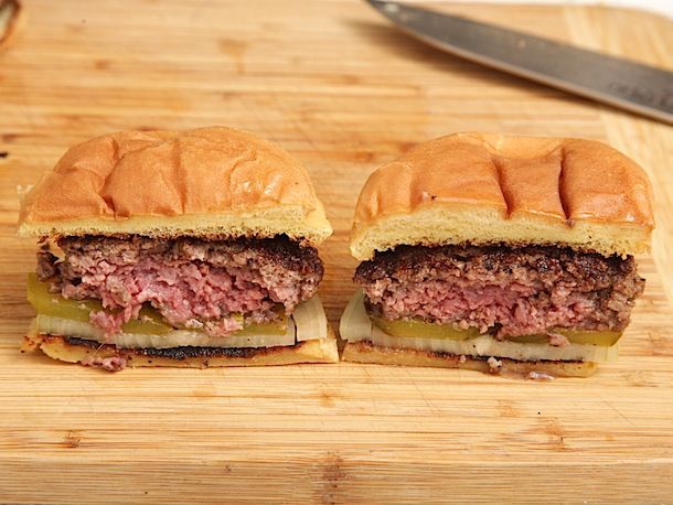 Two thicker burgers one made with coarsely ground beef and the other finely ground beef. They are cut in half to show the interior texture of the patties.