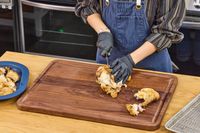 Person carving cooked chicken on a Virginia Boys Kitchens Walnut Wood Cutting Board