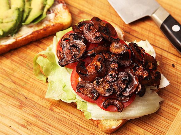 Crispy smoked mushrooms are layered atop the tomato and lettuce of a B.L.A.T. sandwich.