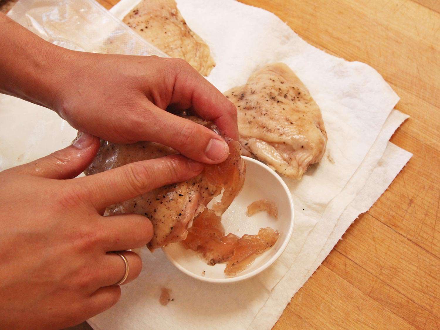 Jelled juices being scraped off of chicken and saved in a bowl.