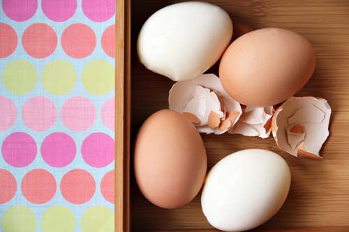 Four hard-boiled eggs, two of them peeled, ready for making Son-In-Law Eggs