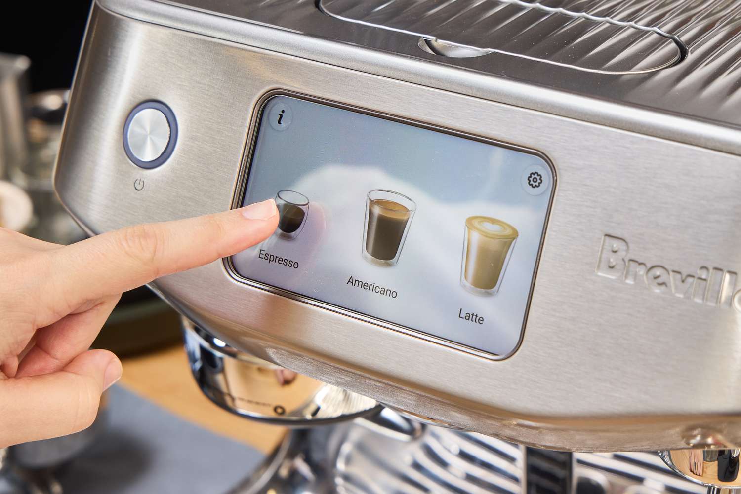 A person presses a button on the Breville Oracle Jet Espresso Machine