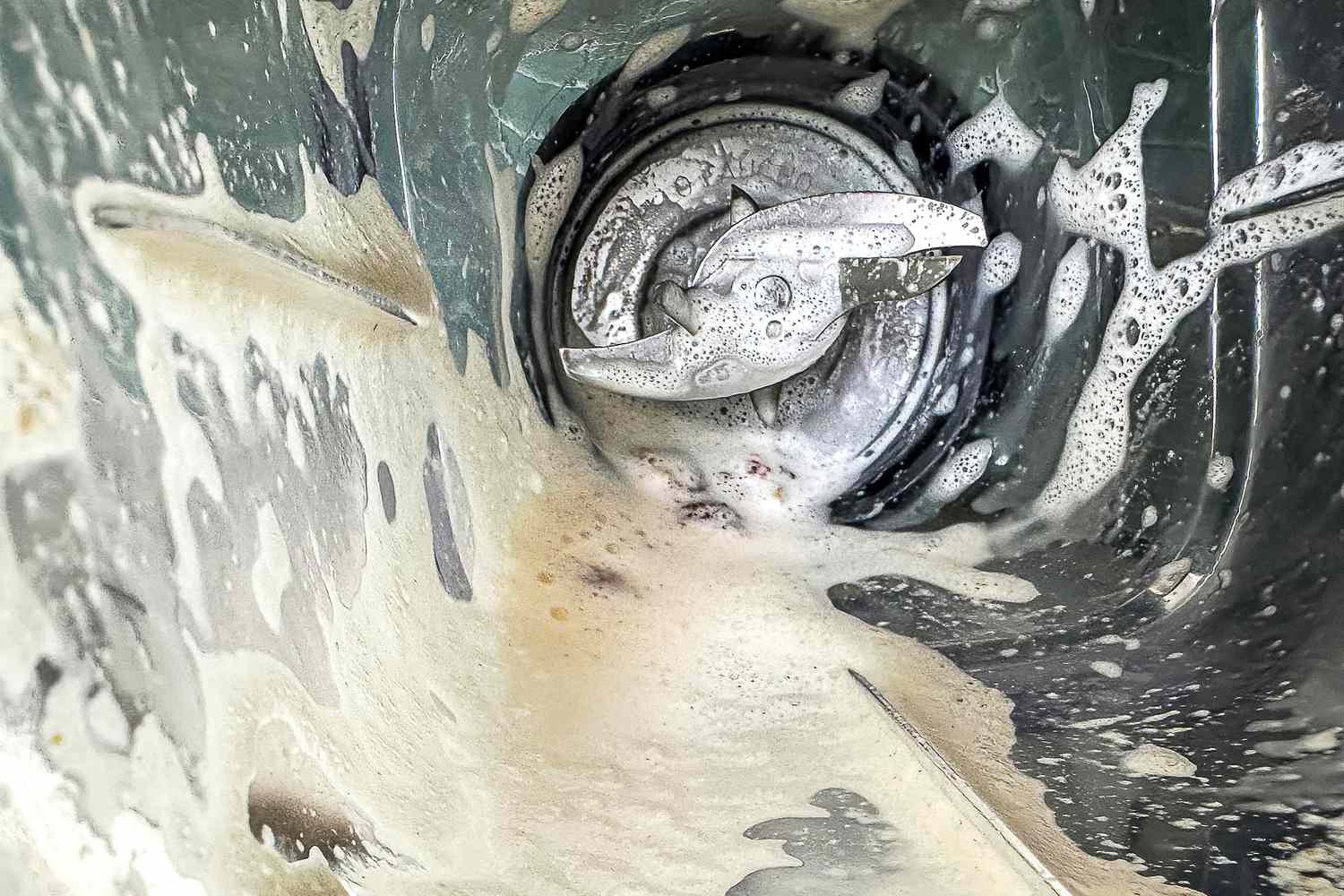 A top-down look at the inside of the Calphalon Auto Speed 68-Ounce Blender jar, with almond milk clinging to the sides of the jar