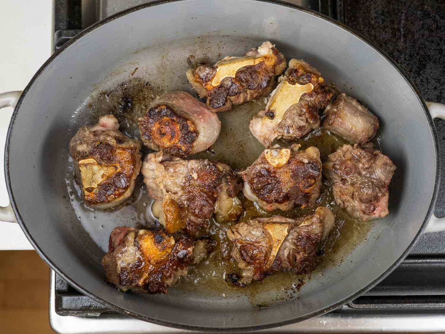 Oxtails browning in a Dutch oven