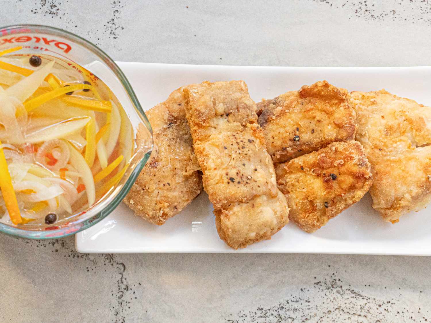 Overhead view of pouring sauce over fish