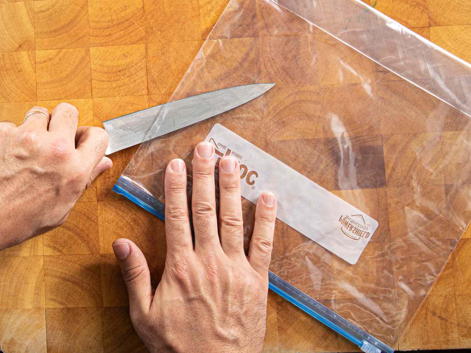 Overhead view of cutting a plastic bag in half.