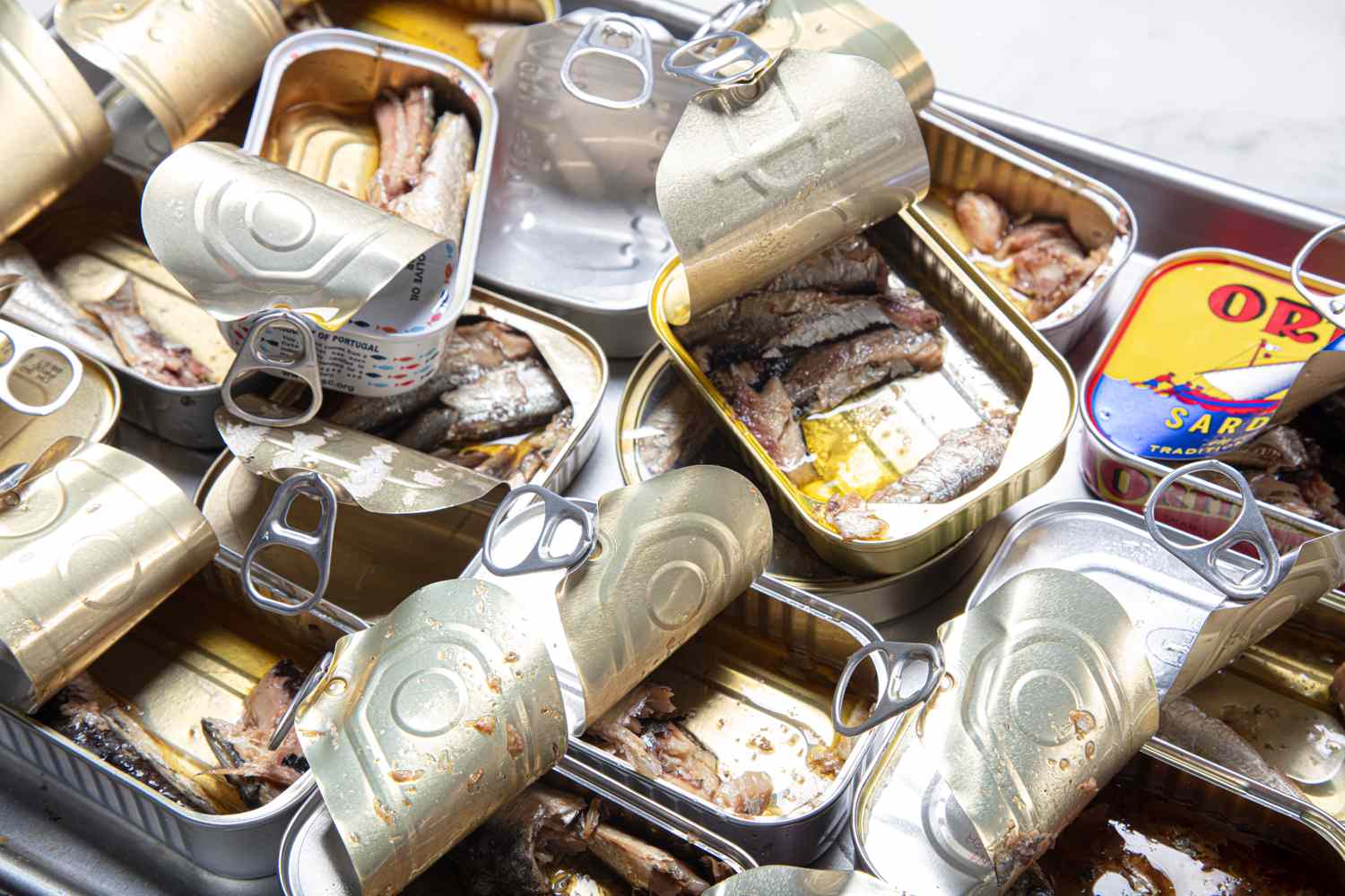 An assortment of opened canned sardines displayed on a tray