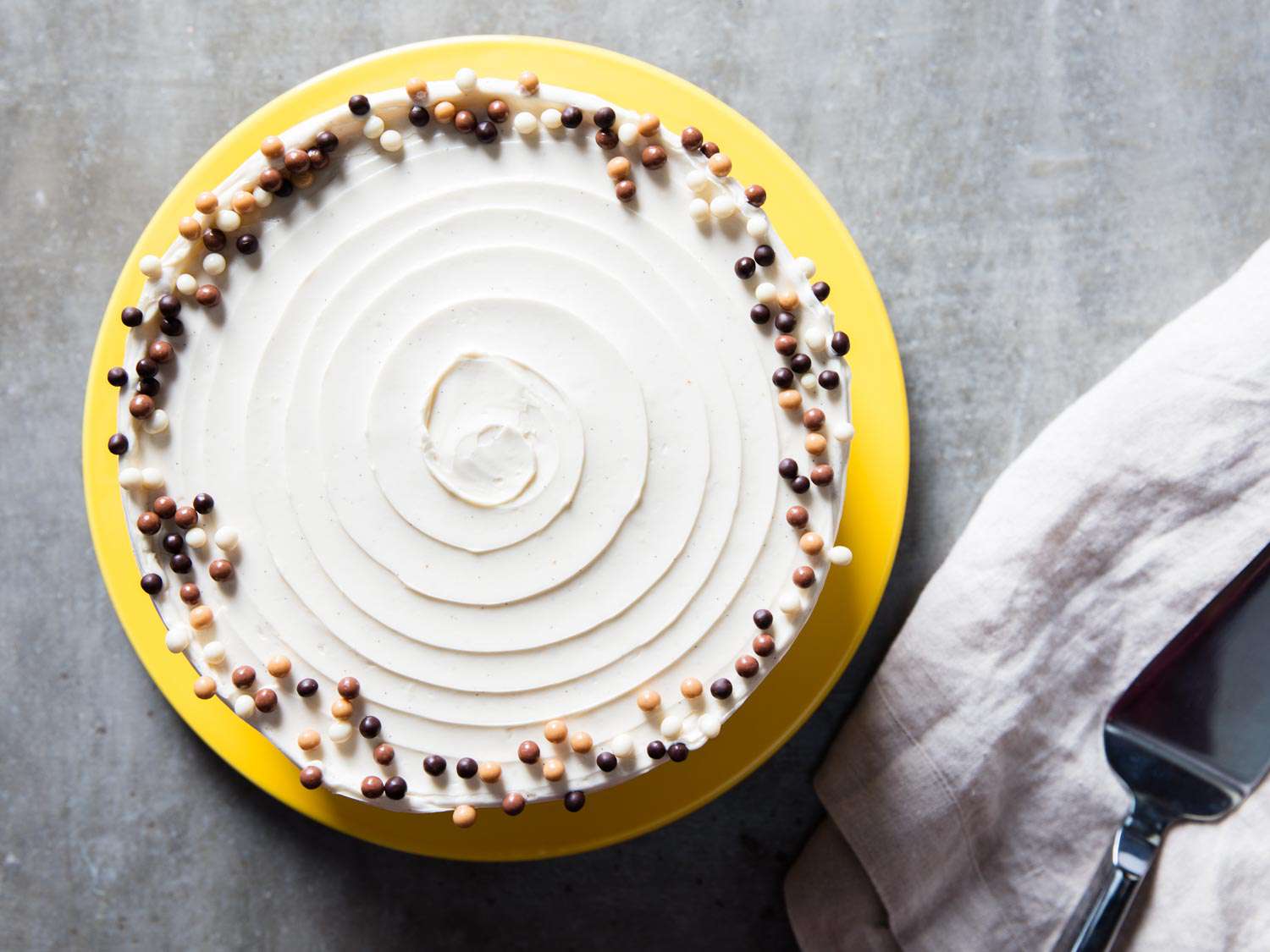 Top down view of a vanilla butter cake that has been decorated with Valrhona pearls.
