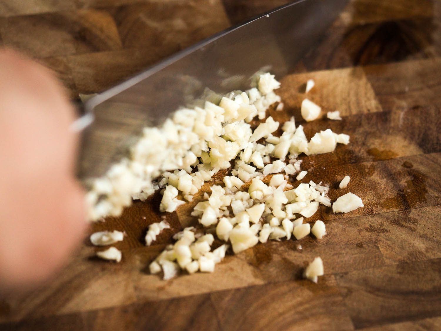 Mincing garlic with a knife.