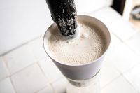 someone stirring nut milk in the chefn nut milk maker strainer