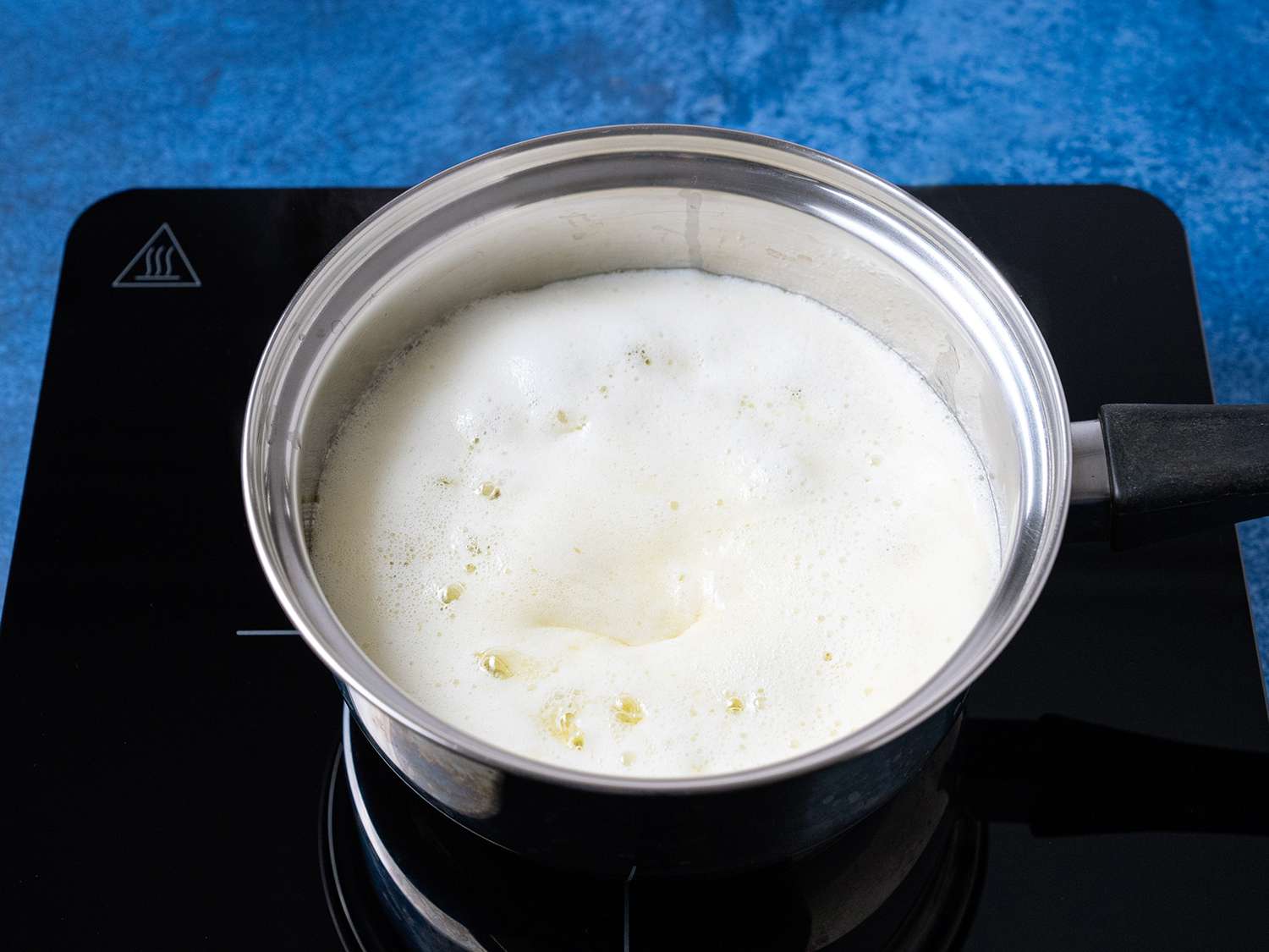 A pot of boiling butter with white foam layer on top