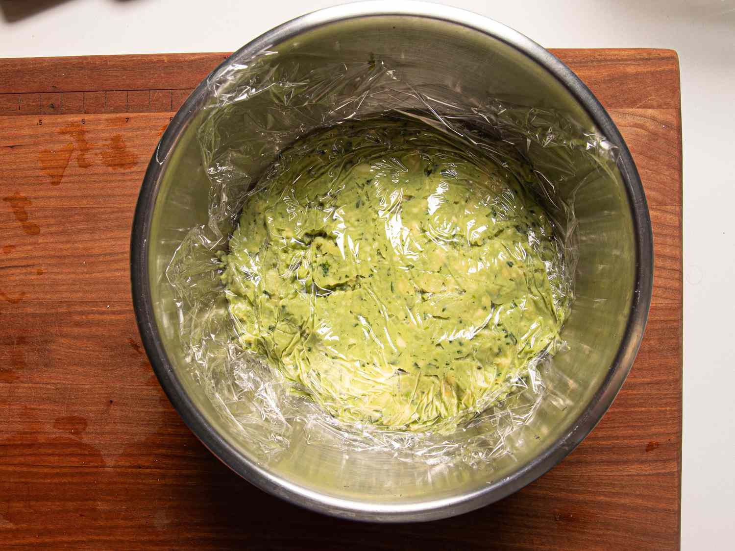 Overhead view of guacamole covered with plastic