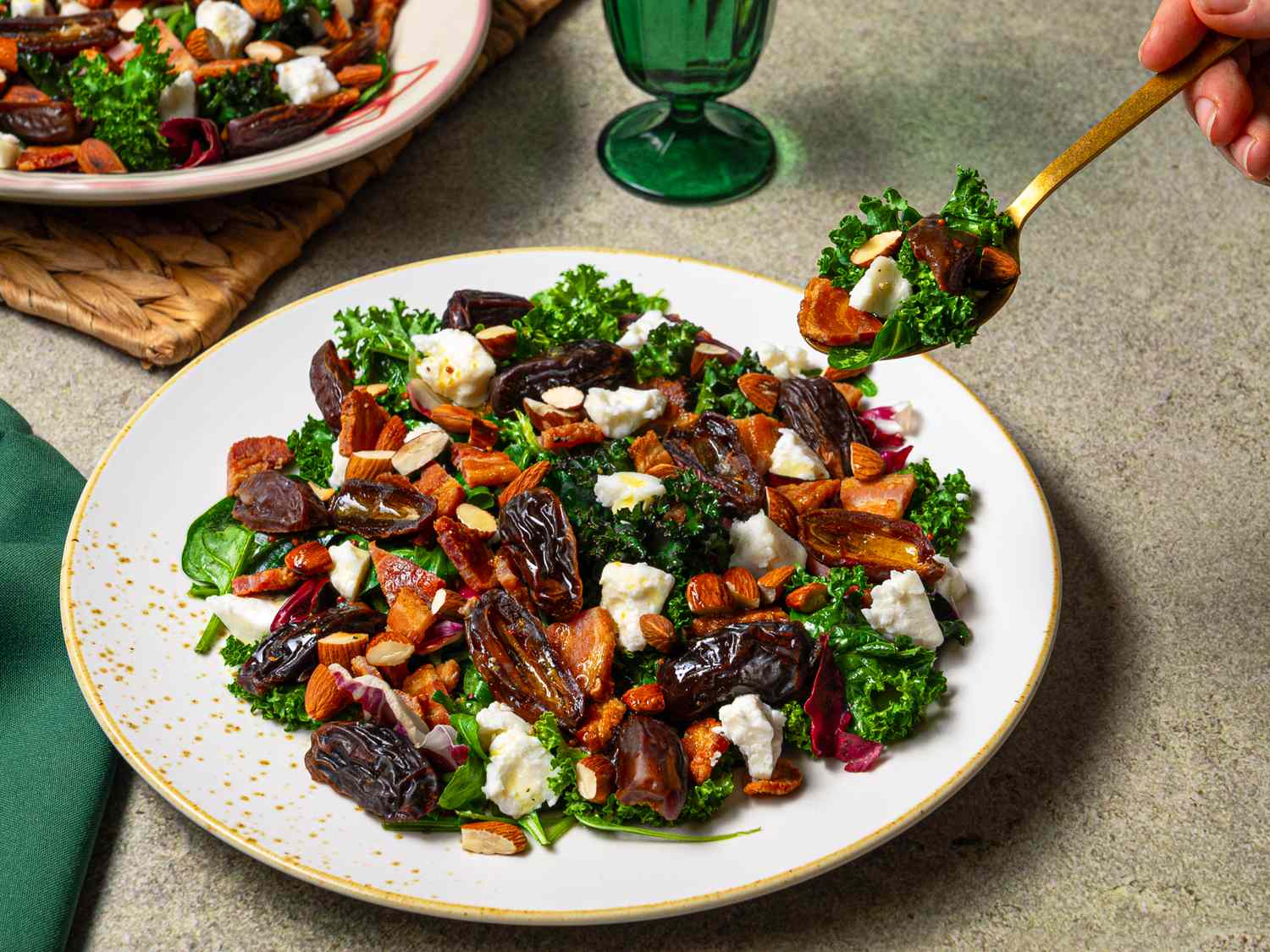 A plated salad with baconwrapped dates spinach kale goat cheese and nuts