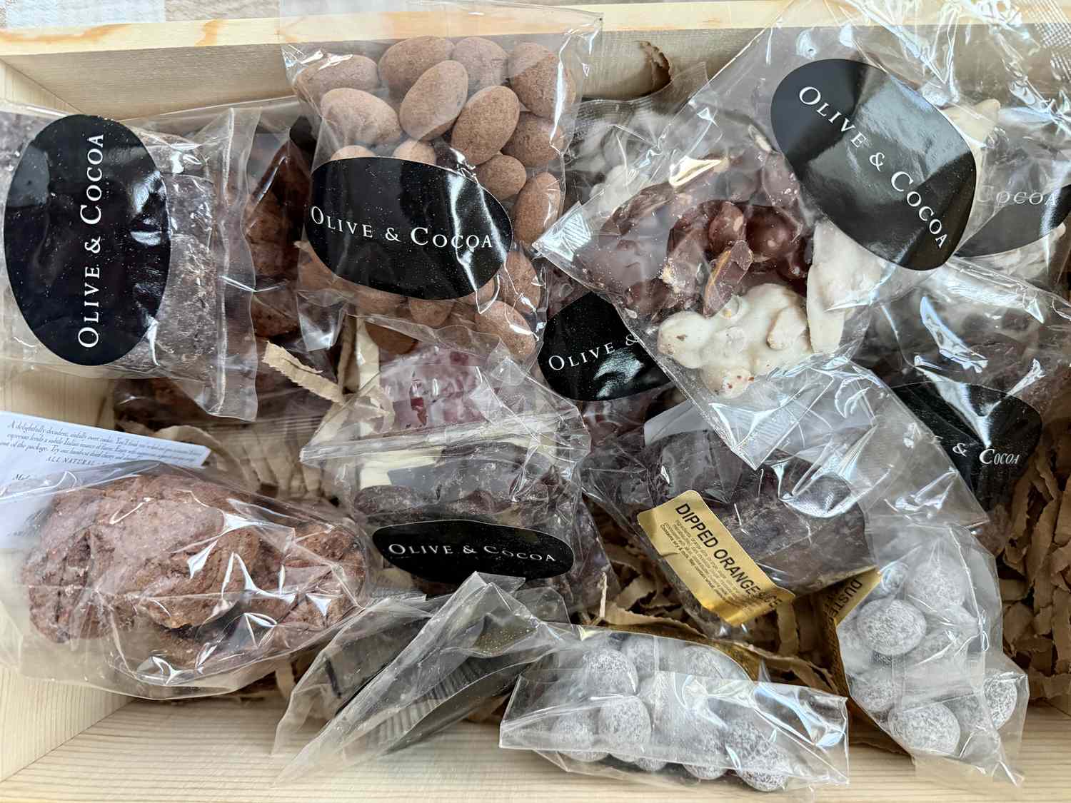 Individually sealed bags of chocolate treats in a wooden crate