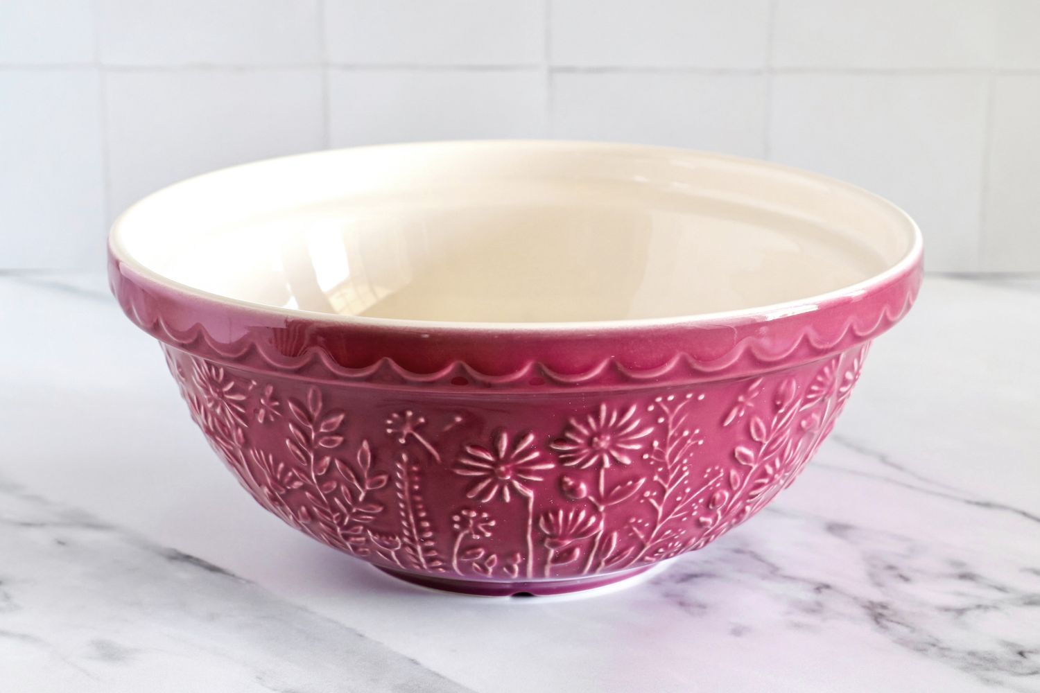 A Mason Cash mixing bowl with floral patterns on a marble countertop
