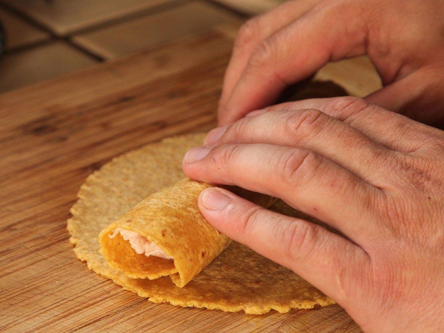 Rolling up turkey in a tortilla. 