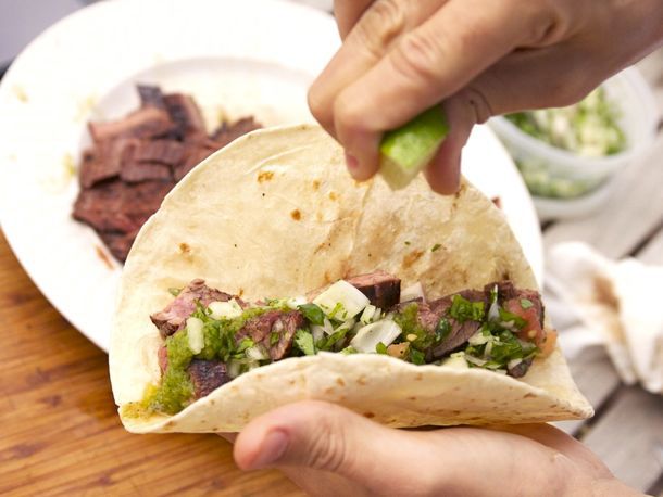 Squeezing lime over a grilled flank steak fajita taco.