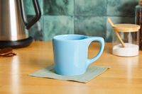 A blue coffee mug on a kitchen countertop.