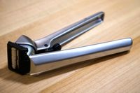 A garlic press on a wooden surface