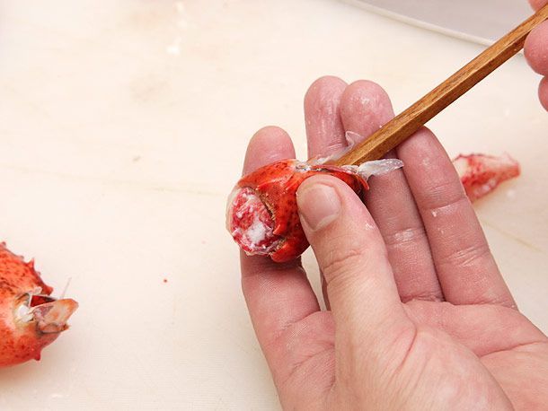 Using a chopstick to push meat out of a lobster knuckle