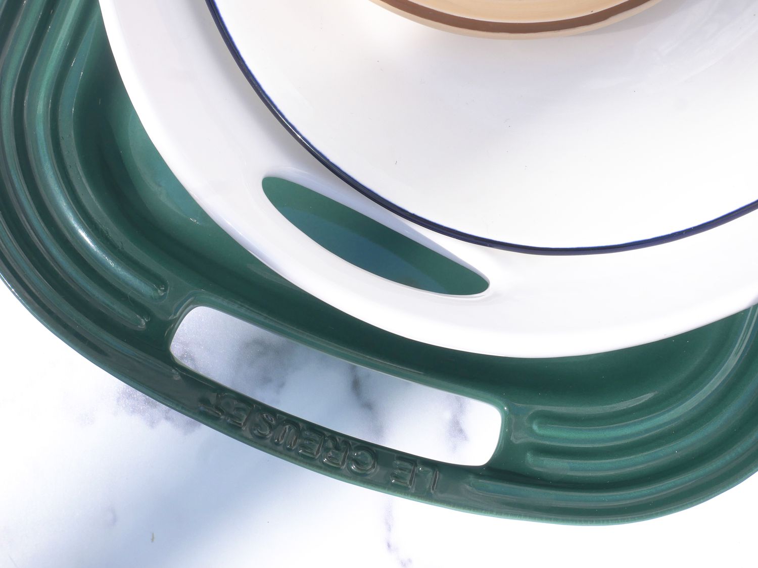 a closeup of the le creuset and williams sonoma handles