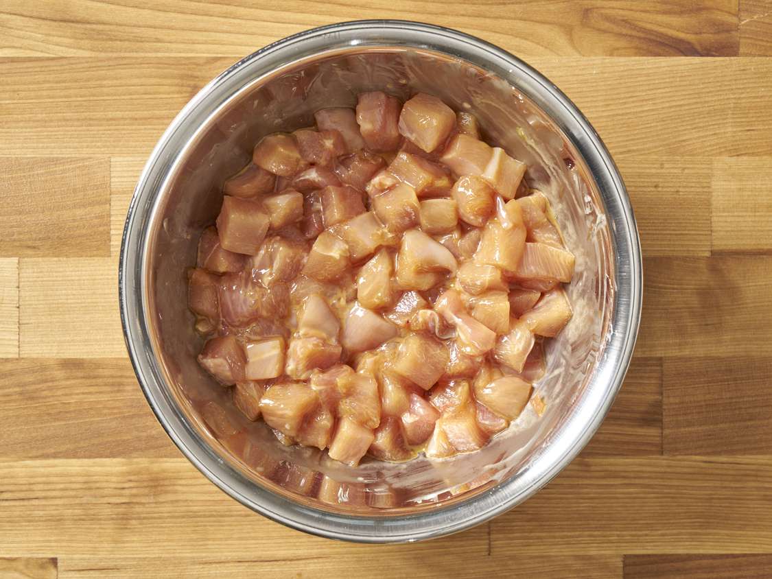 Chicken evenly coated in a thin film of the cornstarch paste in small bowl.