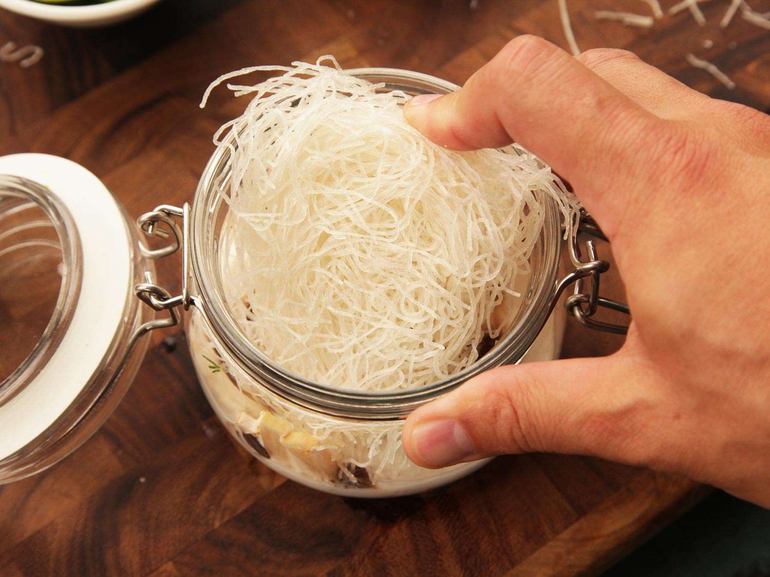 Thin, dried rice noodles are added to the flip top jar.