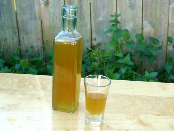 A bottle of DIY drambuie next to a glass of drambuie.