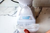 Snowie Little Snowie Max Snow Cone Machine in use, dispensing shaved ice into a bowl