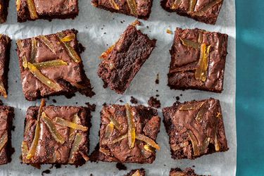 Ginger spiced brownies laid out on a slice of parchment paper.