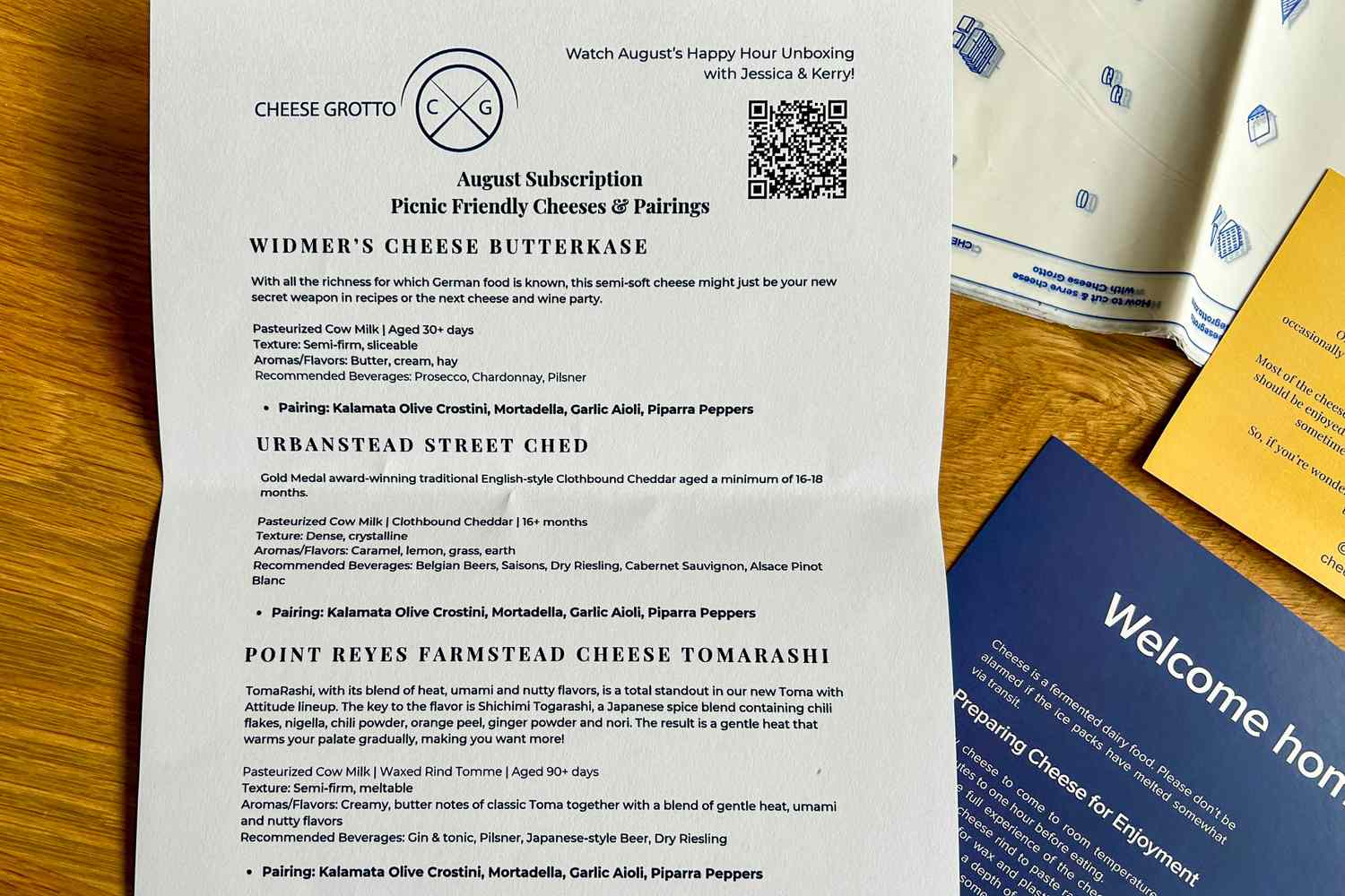 A menu from Cheese Grotto featuring cheese pairing information resting on a wooden surface with other documents nearby