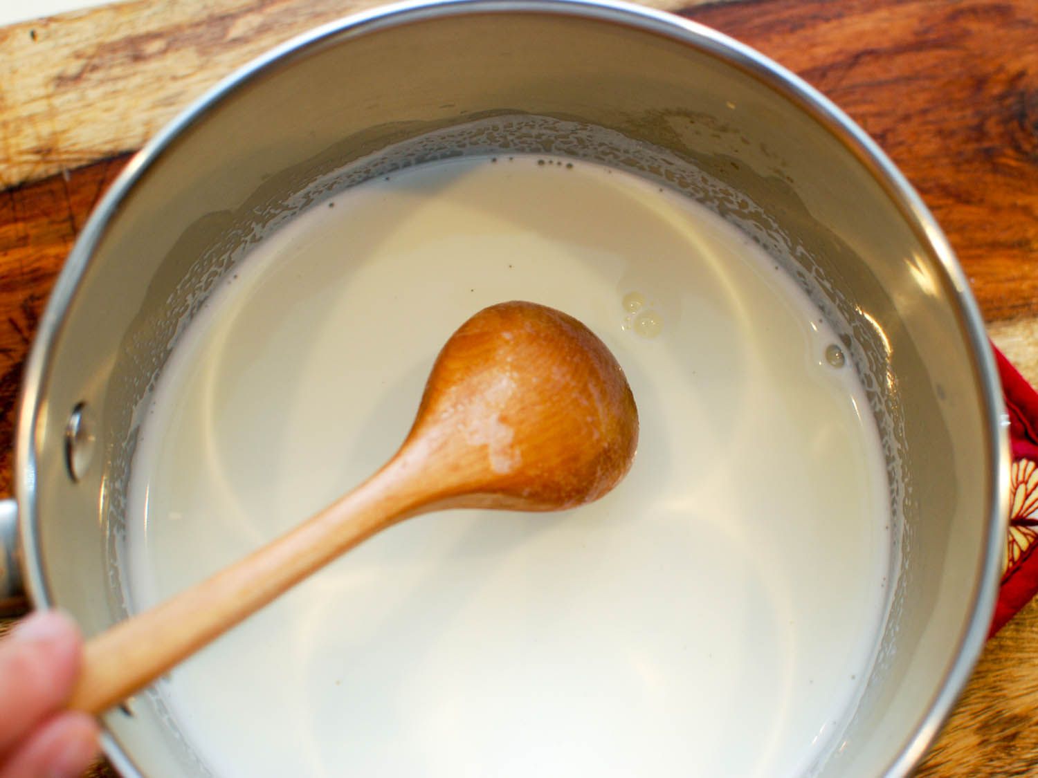 Gelatin is stirred into the milk as it heats.